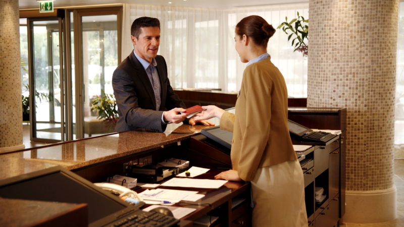Man checking in at hotel reception desk